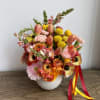 A petit arrangement with sunset snap dragons, peach gerbera daisies, dianthus, and