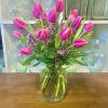 20 stems of pink tulips in a clear vase.