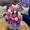 A combination of purple and white roses and pink carnations with a