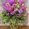 Beautiful purple and violet flowers in a clear glass vase. 