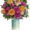 Beautiful aqua vase filled with bright beautiful garden style flowers