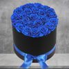 A modern flower arrangement in a black cylinder box filled with blue