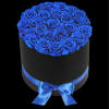 A modern flower arrangement in a black cylinder box filled with blue