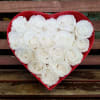 A Heart Shaped box complete with velvety roses immaculately arranged. Packaged in
