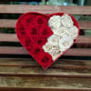A Heart Shaped box complete with velvety roses immaculately arranged. Packaged in