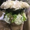 A beautiful arrangement filled with white and green flowers and a few