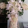 Funeral cross with roses, hydrangeas,  dendrobium orchids, and phalaenopsis orchids.