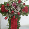 Cross with red carnations, red roses, and pink lilies.