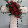 Cross with white daisies and red roses.