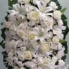 Spray with white roses, cushion daisies, and lilies.
