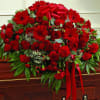All red casket spray made with Roses, Gerbera Daisies, Carnations, Hypericum Berry