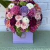 a beautiful bloom box filled with hydrangeas, different types of roses, ranunculus