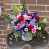 Featuring iris, roses and lisianthus is a pretty white or light pink