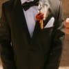 - Handcrafted groom boutonniere featuring rustic charm with moody oranges and peach