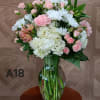 It has white hydrangea, pink spray roses, white daisy  