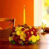 Happy yellow mums and a taper candle bring sunshine to your Thanksgiving