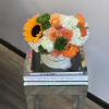 Free spirit roses, hydrangea, sunflowers, and accent flowers nestle in an ivory
