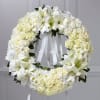 All white wreath made with assorted white flowers.