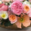 This beautiful arrangement is in a golden vase with a wide variety