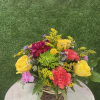 Colorful small compact arrangement in a wicker basket. 