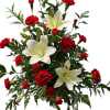 Fresh white Asiatic lilies and carnations are mixed with rich greens in
