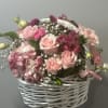 This basket of pink petals is sure to get a warm welcome!