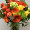 Discover a burst of orange roses, gerber daisies and hydrangea with this