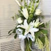Tall arrangement in white and green flowers include casablanca, calla lilies, bells