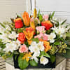 This impressive fall arrangement features orange roses, lilies, light pink spray rose