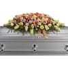 This gorgeous casket spray featuring peach, pink and coral roses is an