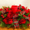 This vibrant centerpiece includes Roses, Mini Carnations Artificial Holiday Berries, a candle