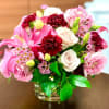 This arrangement includes a variety of blooms arranged in a Marsala color