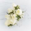 A classic white corsage with silver sheer ribbon, this wrist arrangement looks