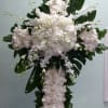 Cross with white roses, white hydrangeas, and white orchids.