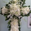 Cross with white roses, hydrangeas, and orchids.