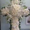 Cross with white hydrangeas, roses, and orchids.