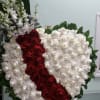 Heart covered in red and white roses with white orchids.