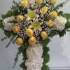 Cross with white hydrangeas, yellow roses and lilies.
