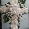 Cross with white roses, hydrangeas, and orchids.