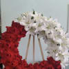 Open wreath with red roses and white lilies.