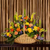 The Bright Fireside Basket is an exquisite floral arrangement, overflowing with life
