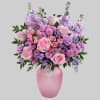 What a delight! Overflowing with pink roses and lavender blooms, this decadent