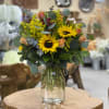 This mix of yellow sunflowers is arranged in a glass mason jar
