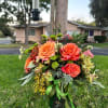 This lively arrangement bursts with the bright hues of orange roses, symbolizing