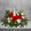 The crystal cross is nestled elegantly among red and white blooms, this
