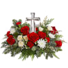 The crystal cross is nestled elegantly among red and white blooms, this