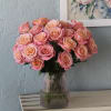 Indulge in the beauty of roses showcased in a designer vase. Experience