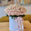 Beauty of pink roses elegantly presented in a chic white hatbox. This