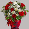 All dressed up in classic Christmas colors, this holiday floral arrangement is