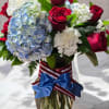 A beautiful aarrangements which includes Blue hydrageanges, red roses and white an